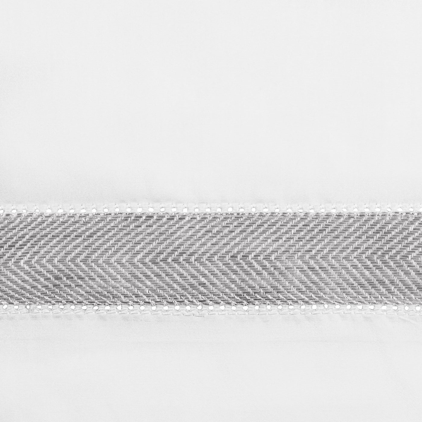 Close-up of silver herringbone woven trim on white linen ground.