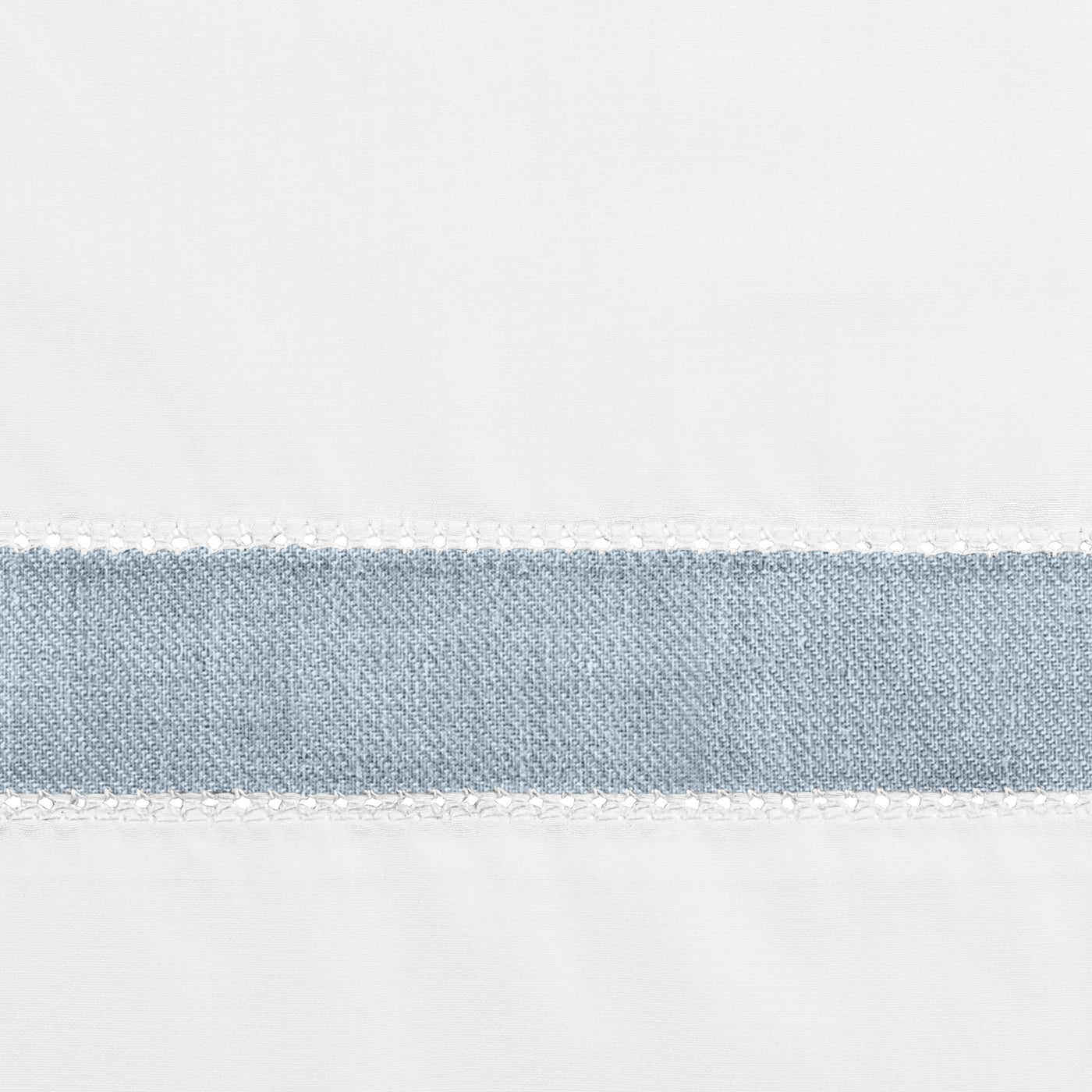 Close-up of dusty blue linen border band with white blanket-stitch trim on white fabric.