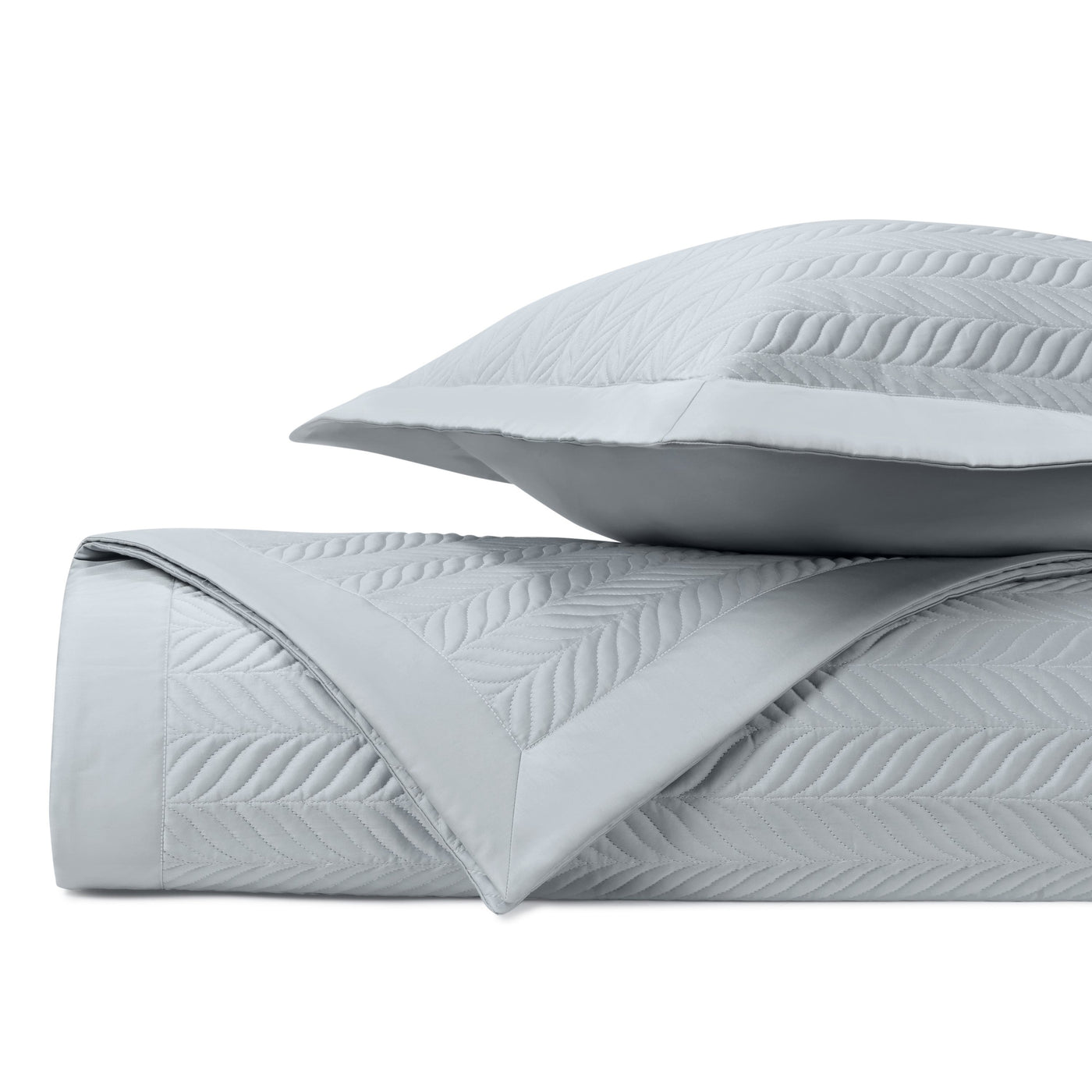 Close-up of silver-blue quilted fabric with embossed herringbone leaf pattern.