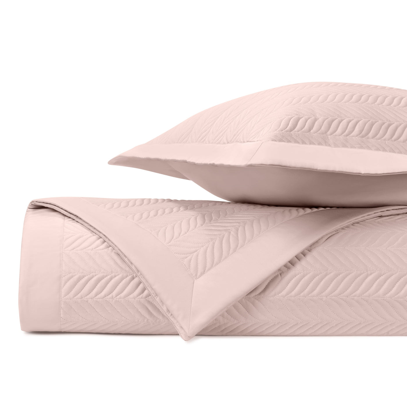 Close-up of blush Zurich quilted coverlet's herringbone stitching pattern with coordinating sham.