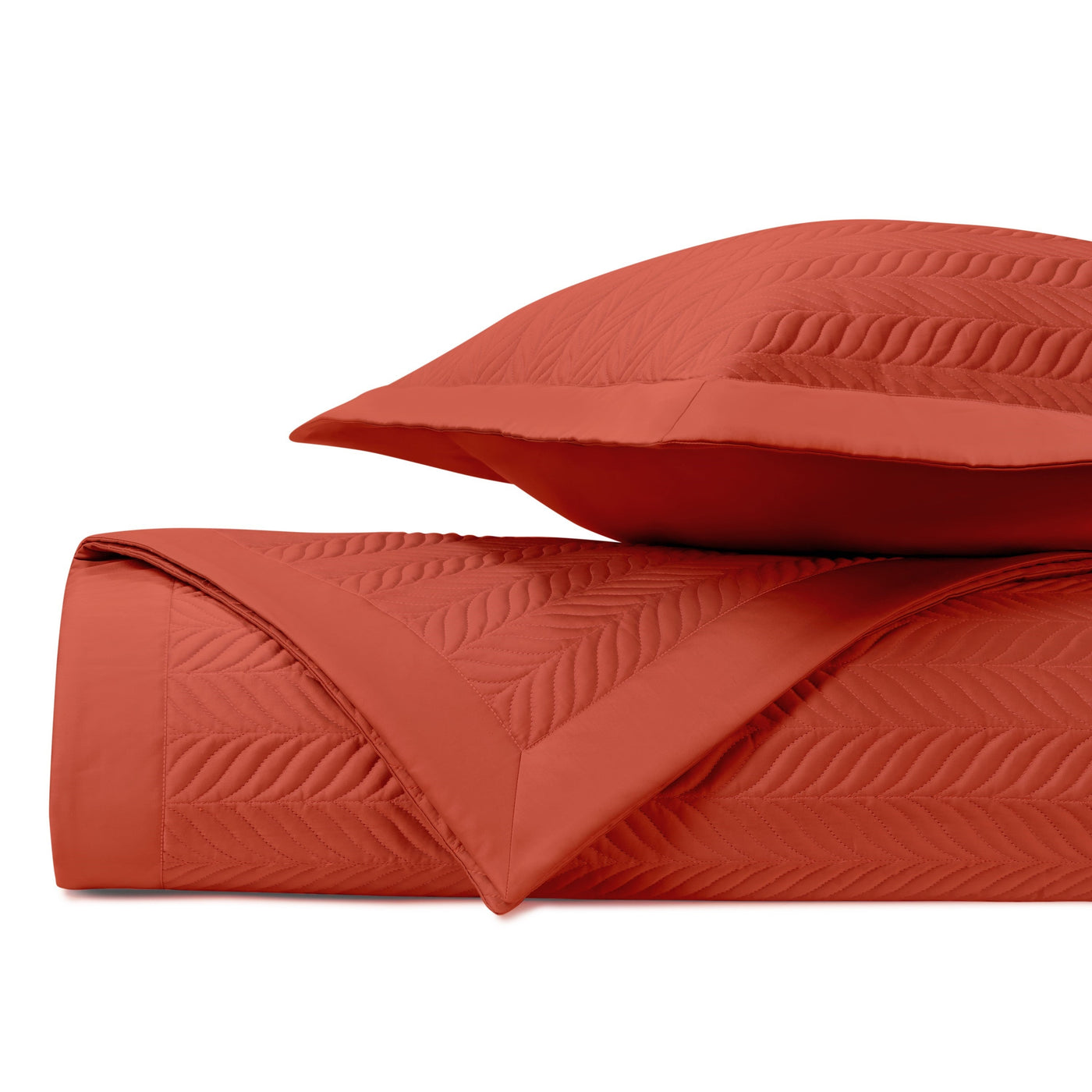 Close-up of Home Treasures Zurich quilted coverlet in terracotta with leaf motif stitching.