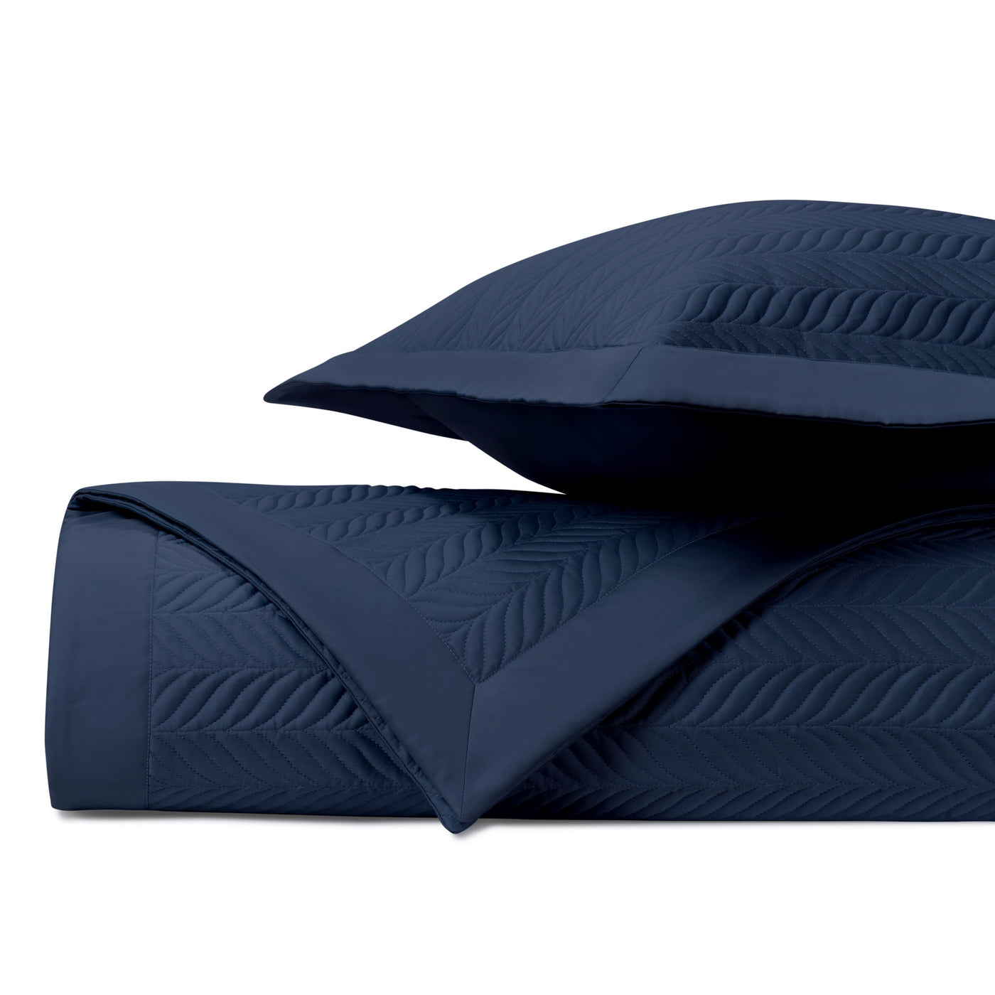 Close-up of navy blue quilted fabric with textured leaf stitching pattern.
