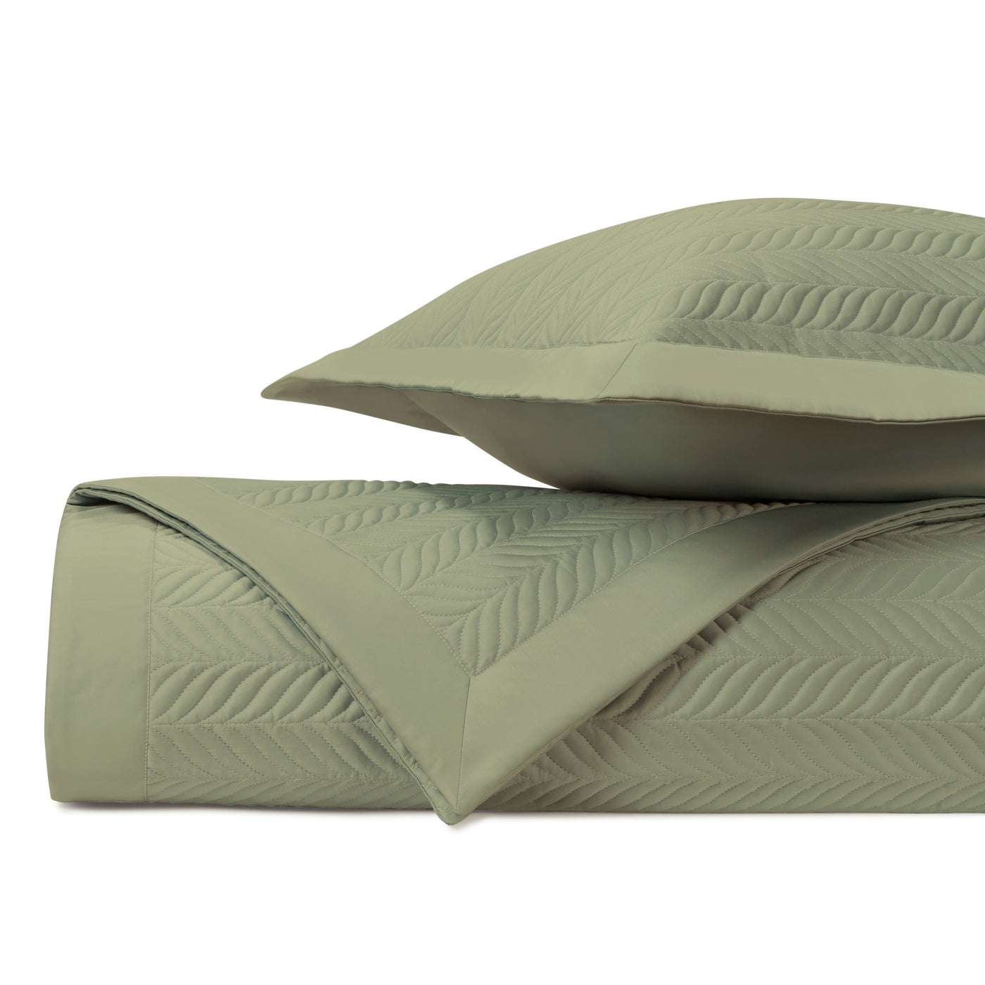 Close-up of Home Treasures Zurich quilted coverlet in sage with leaf motif stitching.