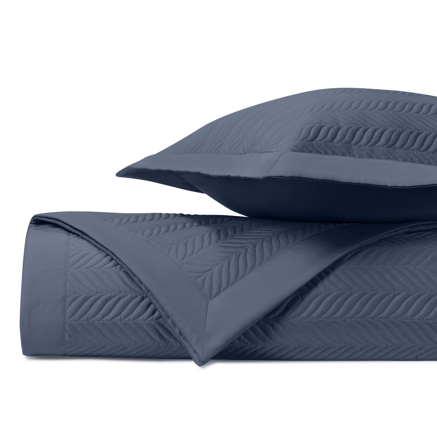 Close-up of navy quilted fabric with embossed chevron leaf pattern.