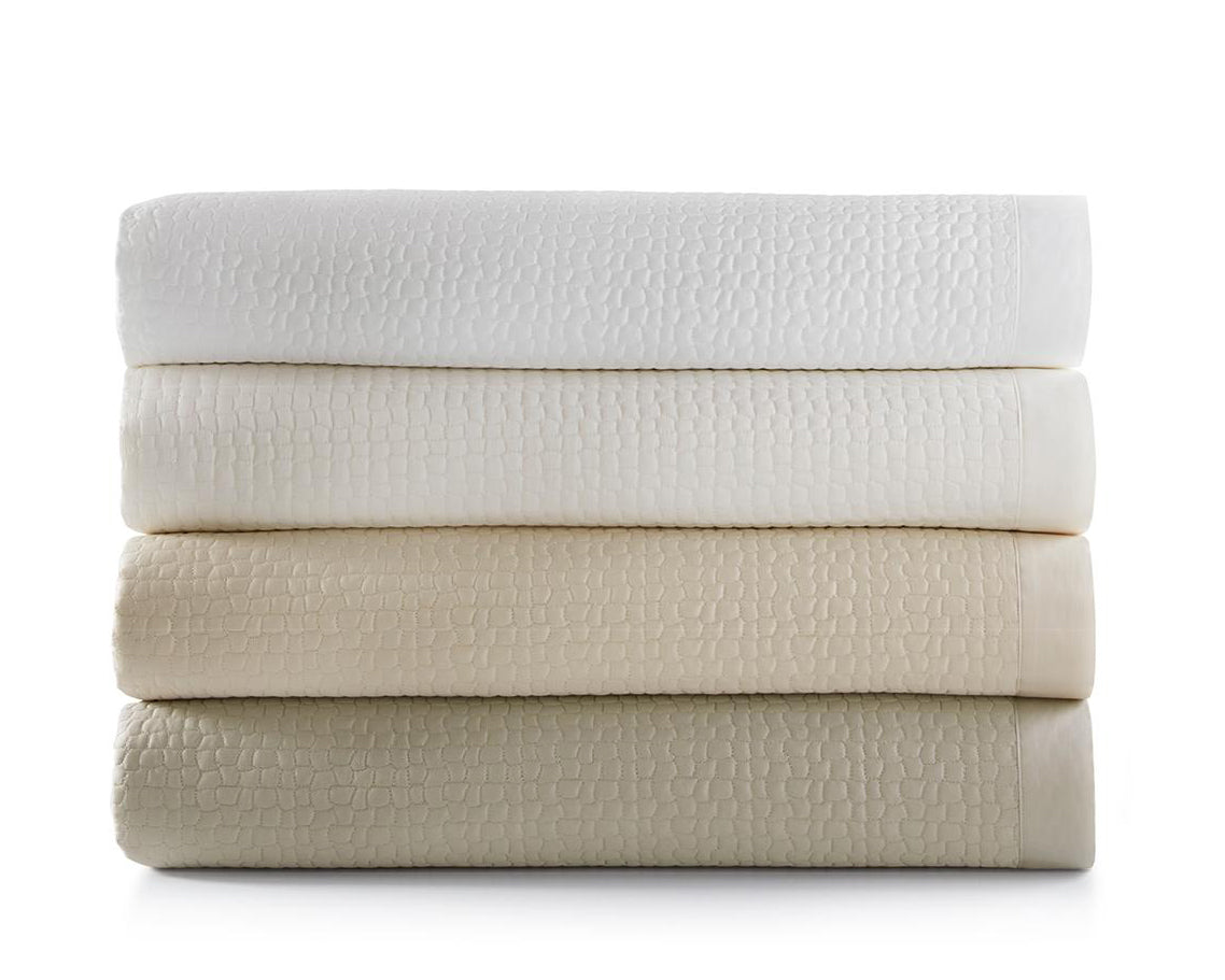 Peacock Alley's Hamilton Coverlet sheet set in four colors, neatly stacked