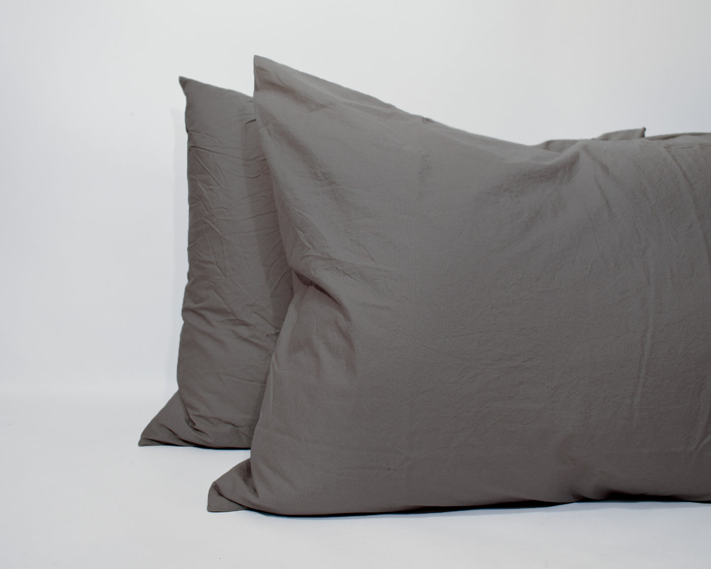 A Linen Society Vintage Percale fitted sheet in gray Italian cotton percale is displayed upright against a plain white background.