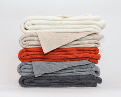 LETTO Domenica throws stacked in ivory, linen, terracotta, and slate cotton knit.