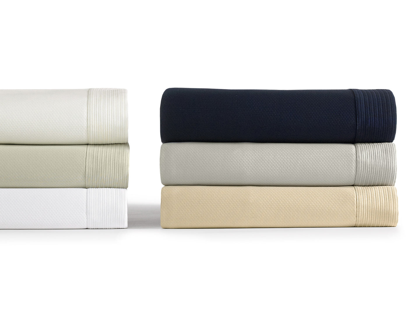 Peacock Alley's Angelina coverlet neatly stacked in six colors