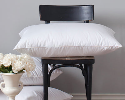 St. Geneve Europa white pillows stacked on a black wooden chair