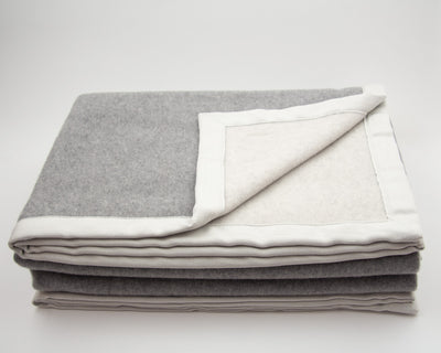 LETTO Monte Bianco blanket folded in silver grey wool with ivory linen border trim.